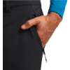 Hand eines Menschen steckt in der Seitentasche einer schwarzen Hose