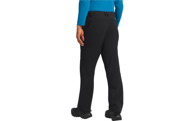 Beine und Unterkörper einer Person in schwarzer Hose und blauer Jacke