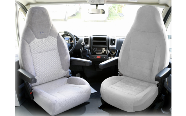 Deux sièges de voiture gris à l'intérieur d'un véhicule avec accoudoirs et vue à travers le pare-brise avant