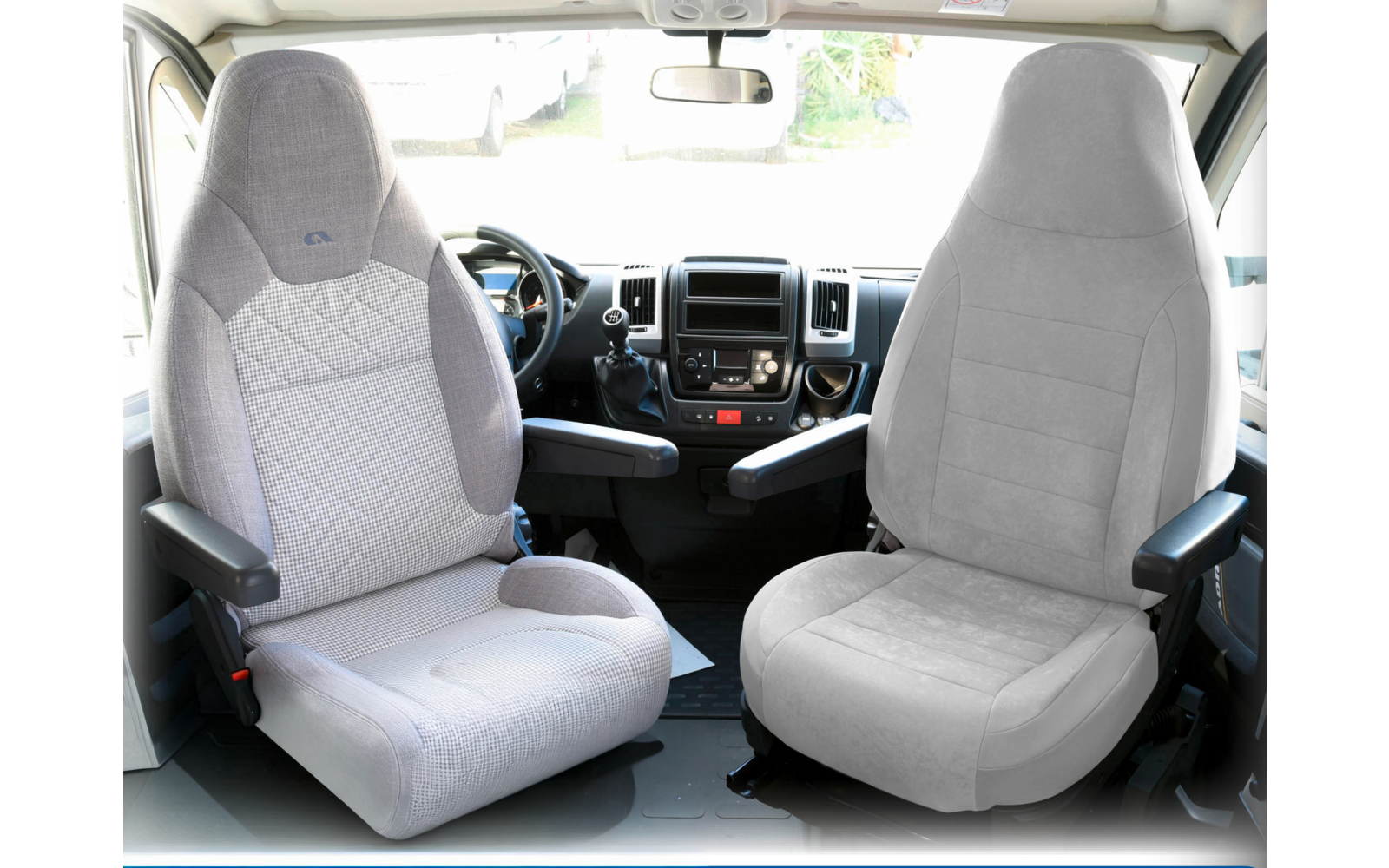 Two gray car seats inside a vehicle with armrests and a view through the front windshield