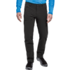 Vista parcial de una persona de pie desde la cintura hasta los pies con pantalones outdoor negros con bolsillos con cremallera, una prenda de manga larga azul y zapatos de senderismo negros
