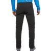Vista trasera de una persona de pie que viste pantalones largos negros, una prenda superior azul claro y zapatos grises; manos a los lados, bolsillos traseros visibles
