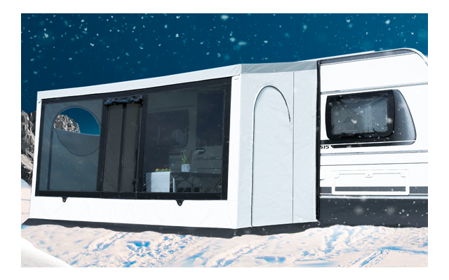 Caravana blanca con tienda adjunta sobre nieve bajo un cielo nocturno despejado con estrellas