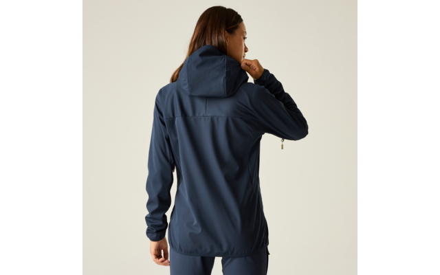 Persona vista de espaldas con chaqueta con capucha azul oscuro y pantalones a juego sobre fondo claro, mano izquierda en el borde de la capucha, mano derecha relajada junto al cuerpo