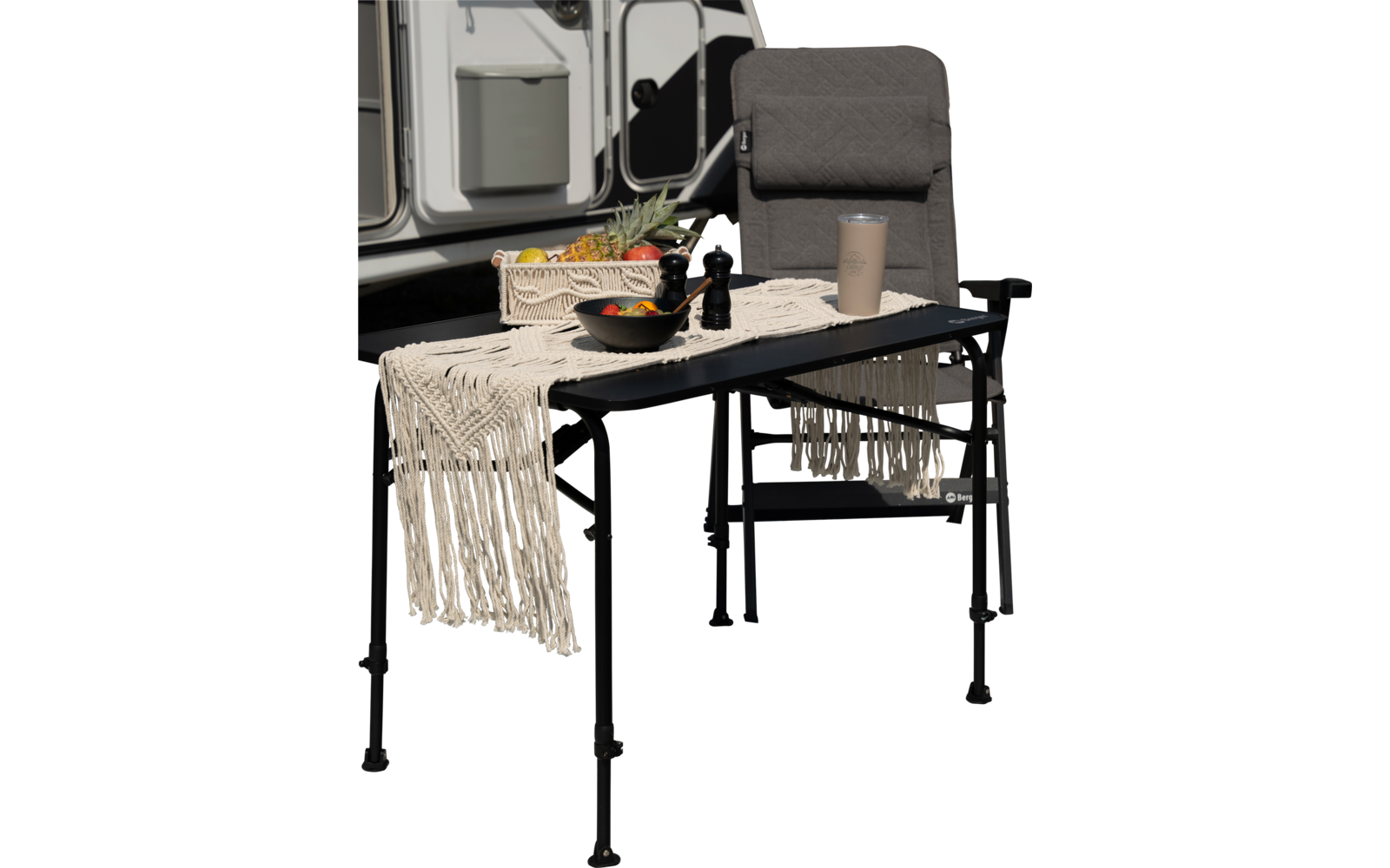 Chaise et table avec nappe et bouteille devant une caravane en plein air