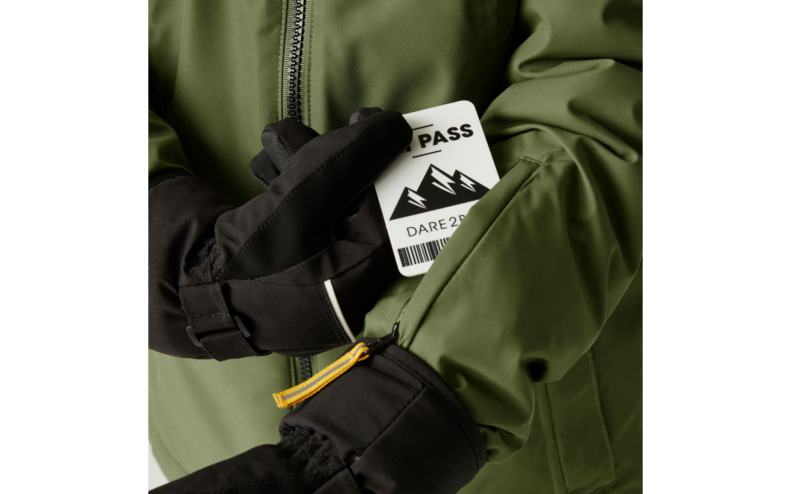 Hände mit schwarzen Handschuhen halten eine grüne Jacke und eine weiße Skiauszeichnung