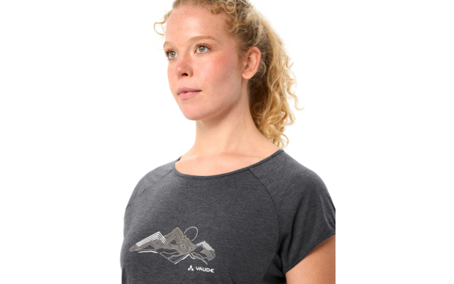 Person mit lockigem blondem Haar, trägt graues T-Shirt mit Bergmotiv und VAUDE-Logo, Blick nach rechts, Porträt bis zur Brust, weißer Hintergrund