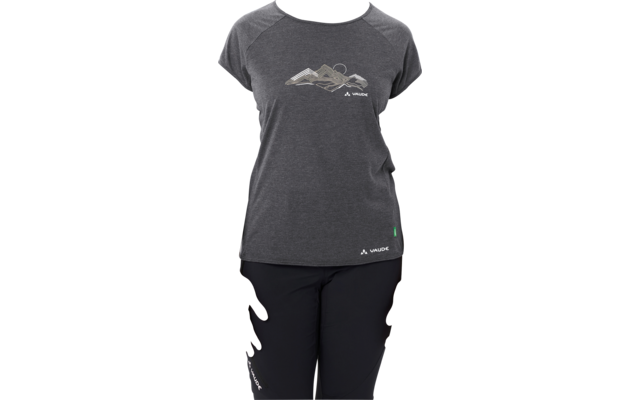 Person standing facing the camera against a white background, wearing a dark gray T‑shirt with a mountain graphic and black pants, hair pulled back