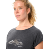 Person mit lockigem blondem Haar, trägt graues T-Shirt mit Bergmotiv und VAUDE-Logo, Blick nach rechts, Porträt bis zur Brust, weißer Hintergrund