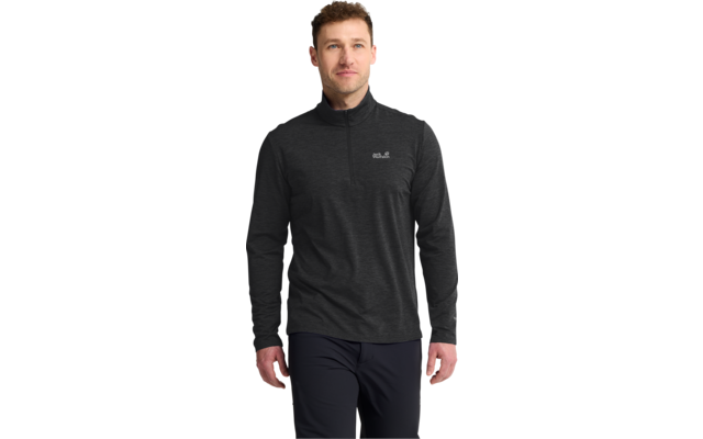 Mann steht frontal, trägt dunkles Langarmshirt mit kurzem Reißverschluss und dunkle Hose vor weißem Hintergrund