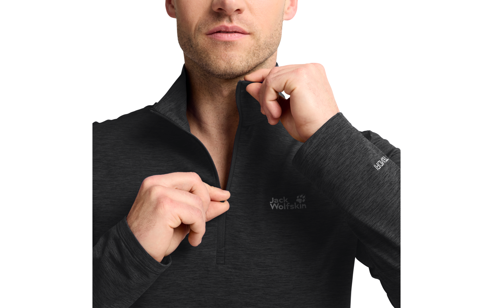Unterer Gesichtsbereich, Hals und Oberkörper einer Person, die mit beiden Händen den Reißverschluss eines dunklen Jack Wolfskin-Fleecepullovers hochzieht; Logo auf Brust und Ärmel; Ring an einem Finger