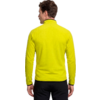 Person von hinten in gelbgrüner Fleecejacke mit hohem Kragen und schwarzer Hose, kurze braune Haare, weißer Hintergrund