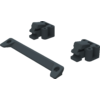 Drei dunkle Kunststoffteile: zwei blockförmige Teile mit zylindrischen Öffnungen und ein flaches, leicht gebogenes Verbindungsstück mit Bohrungen an den Enden