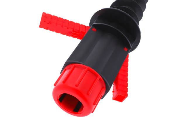 Nahaufnahme eines schwarzen Kunststoffzylinders mit roter, gerillter Kappe, zwei roten rechteckigen Laschen und gewellter Oberfläche