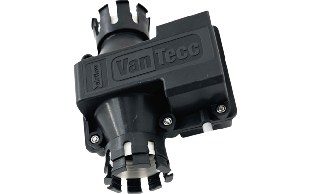 Objet en plastique noir avec le logo embossé "VanTecc", deux parties cylindriques aux ouvertures à bords dentelés, quatre vis visibles et une petite languette blanche, fond gris clair