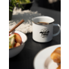 Tasse de café, bol avec des fruits à côté, croissant sur une assiette au premier plan