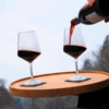 Deux verres à vin sur un plateau, l’un est rempli de vin rouge