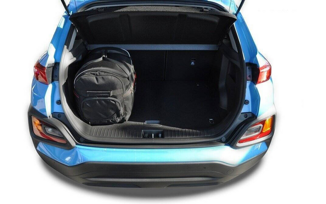 Offener Kofferraum eines blauen Autos mit einem schwarzen Rucksack links im Gepäckraum