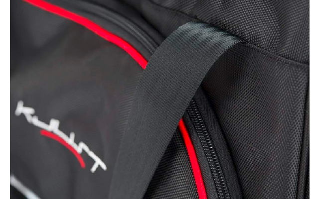 Nahaufnahme einer schwarzen Tasche mit roter Paspel, schwarzem Tragegriff, Reißverschluss und weiß-rotem gesticktem Schriftzug