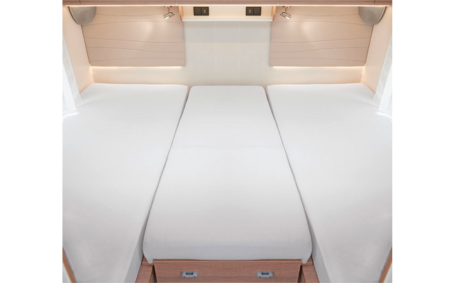 Trois matelas blancs côte à côte dans une pièce lumineuse avec des tiroirs en bois en dessous