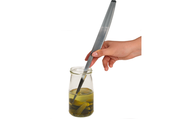 Hand houdt metalen pincet die een augurk uit een glazen pot met vloeistof pakt