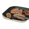 Grillpan met meerdere gegrilde vleesplakken en gegrilde aubergijnplakken; tang houdt een stuk vast