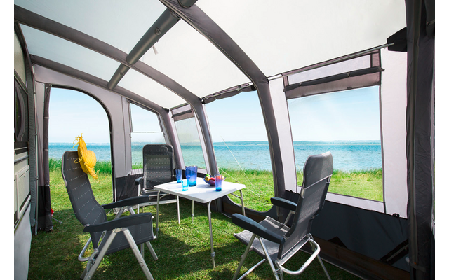 Vue depuis un balcon couvert sur la mer et la côte, avec deux chaises pliantes, une petite table et des boissons