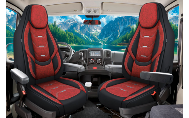 Innenraum eines Fahrzeugs mit zwei roten Vordersitzen, Armlehnen, Lenkrad, Armaturenbrett und Bergen mit See sichtbar durch die Windschutzscheibe