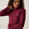 Frau in bordeauxrotem Pullover mit Reißverschluss und Logo auf der Brust