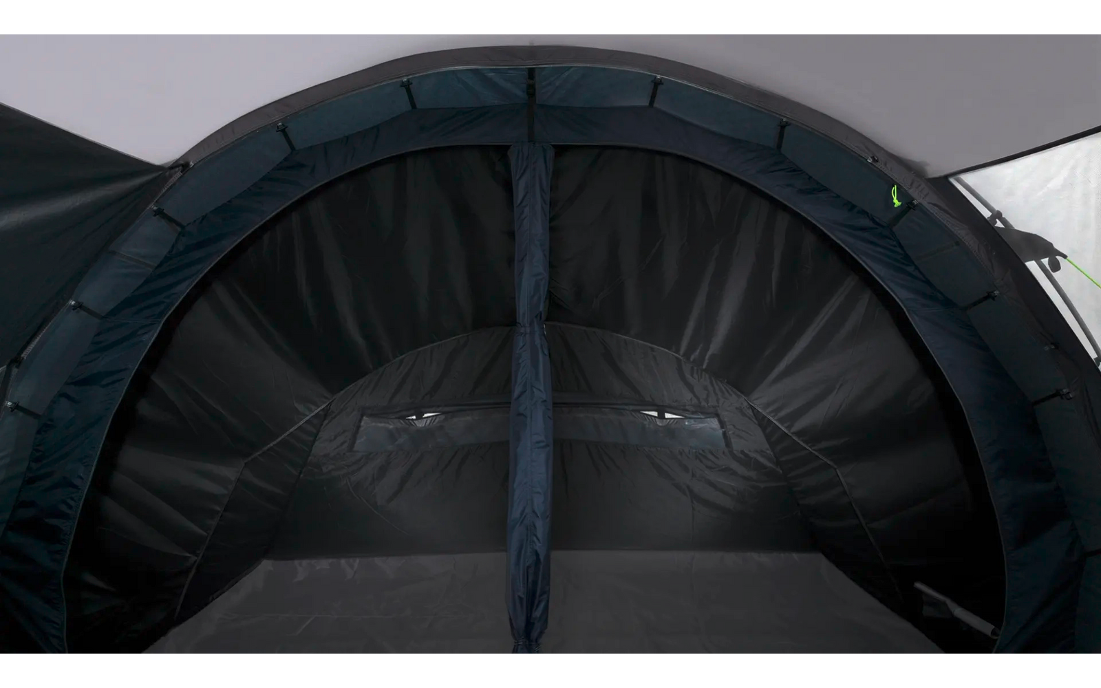 Donkere binnenkant van een tent met gebogen dak, verticale middennaad en klein rechthoekig gaasraampje