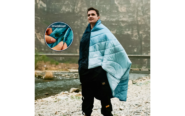 Ein Mann steht an einem Flussufer und trägt eine blaue Decke, im Detailbild sind bunt bemalte Fingernägel zu sehen