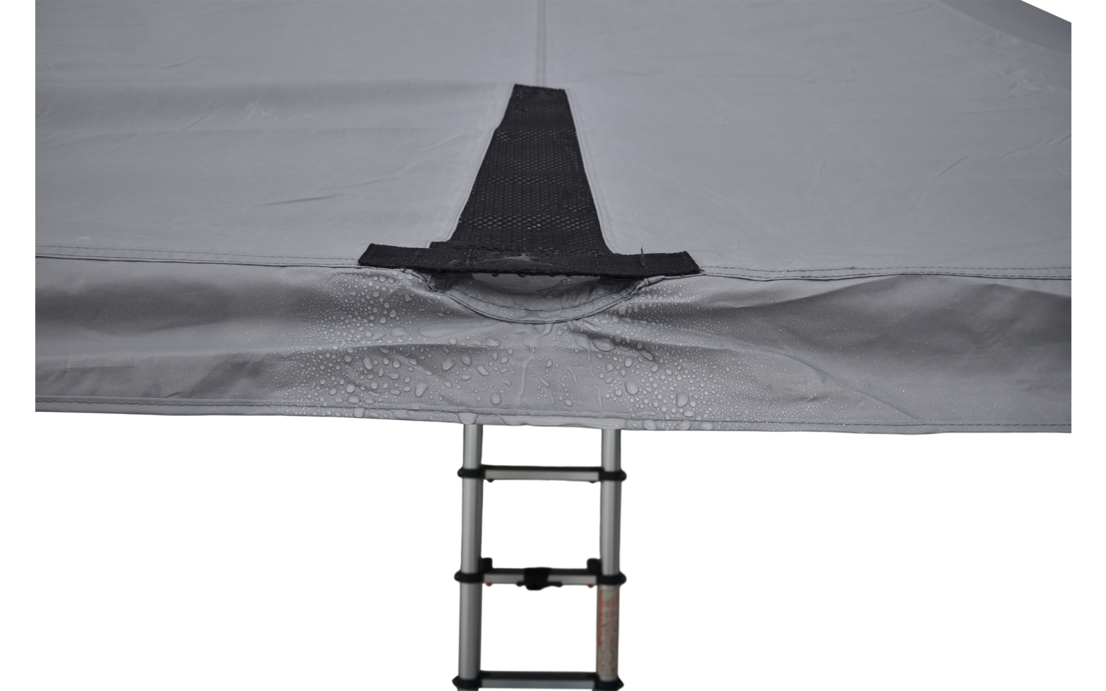 Grauer Stoff mit schwarzem Verstärkungsstreifen und Wassertropfen; teleskopische Metallleiter mit Sprossen ragt von unten ins Bild