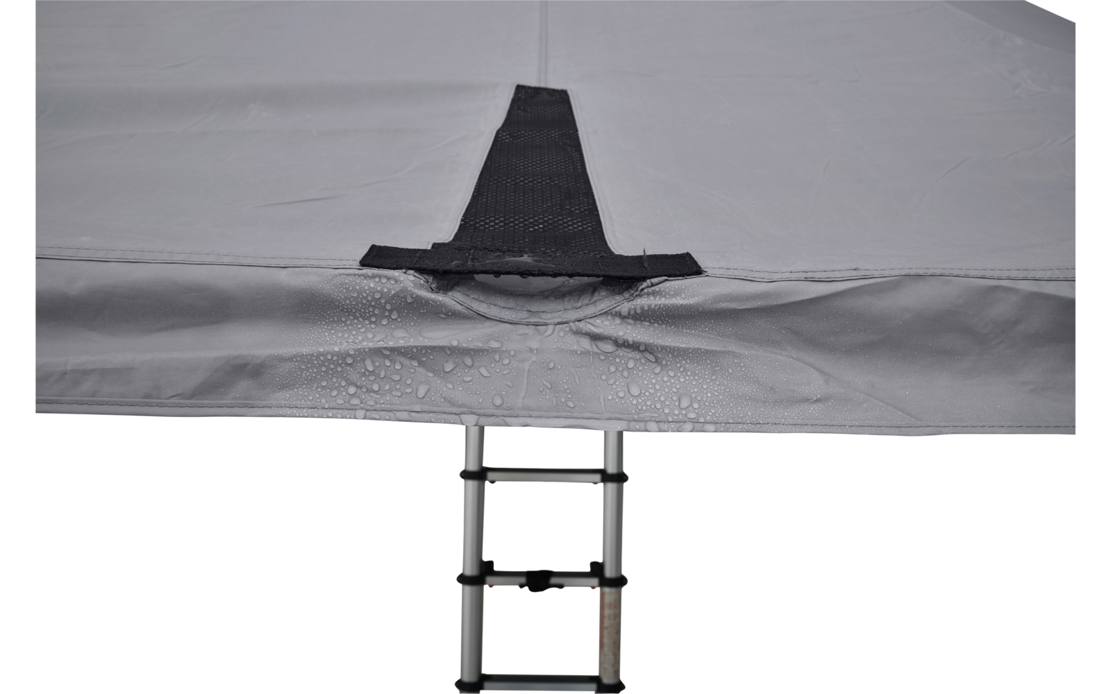 Teil einer hellgrauen Stofffläche mit schwarzer Schlaufe in der Mitte, Wassertropfen darauf und eine teilweise sichtbare Teleskopleiter unten