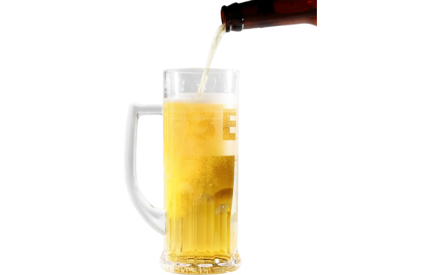 Brown bottle pouring golden beer into clear handled glass mug, foam on top, white background