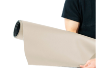 Personne tenant un tapis beige roulé dans les mains
