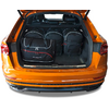 Geöffneter Kofferraum eines orangefarbenen Autos mit drei schwarzen Taschen