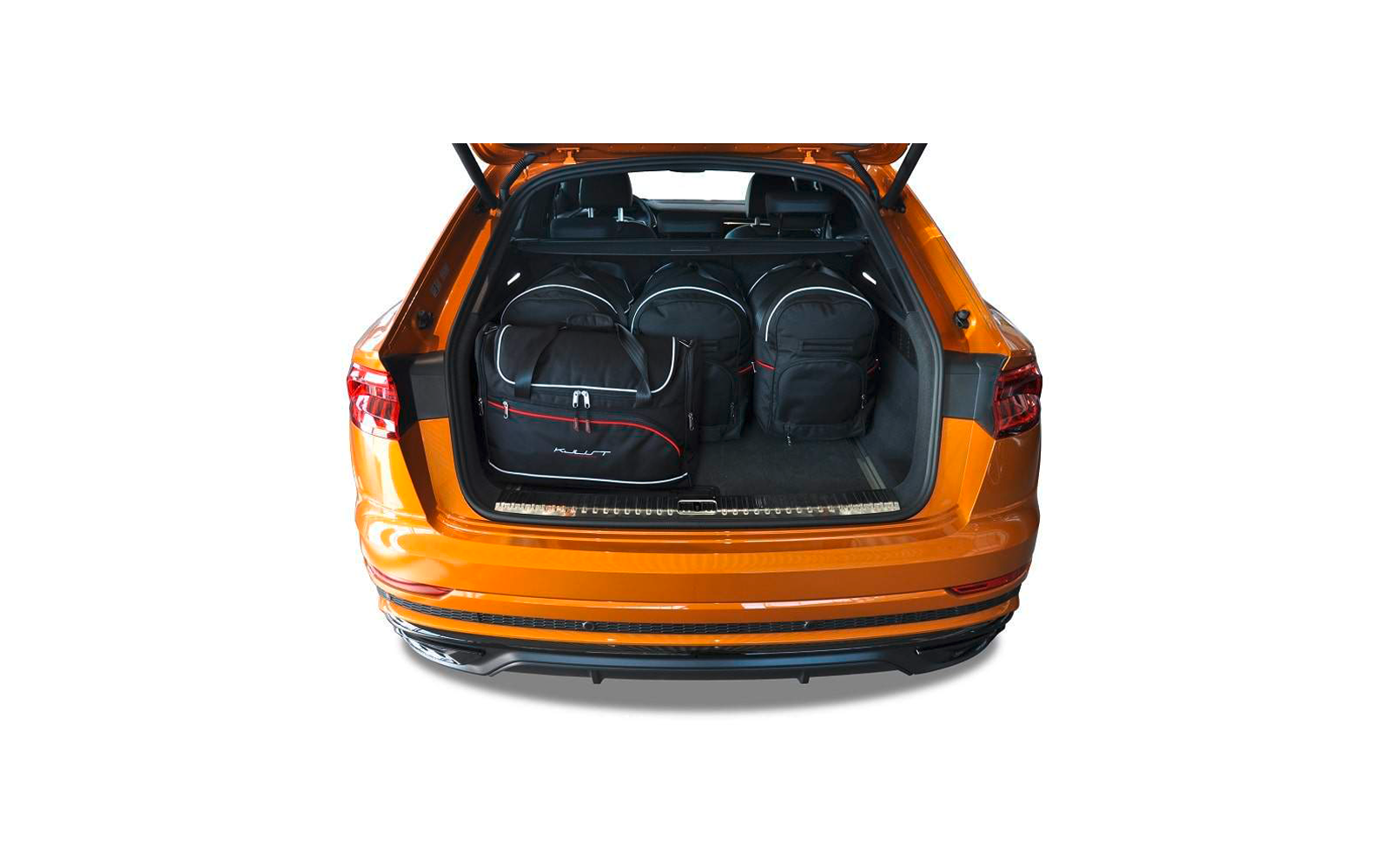 Geöffneter Kofferraum eines orangefarbenen Autos mit drei schwarzen Taschen