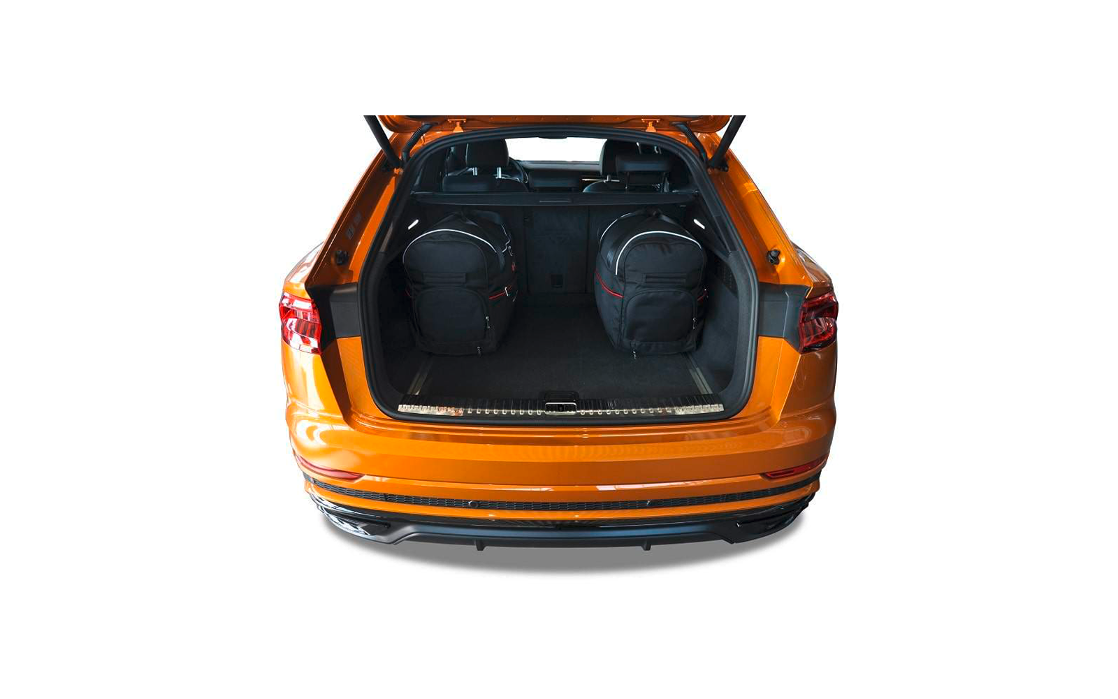 Geöffneter Kofferraum eines orangefarbenen Autos mit zwei schwarzen Rucksäcken im Innenraum