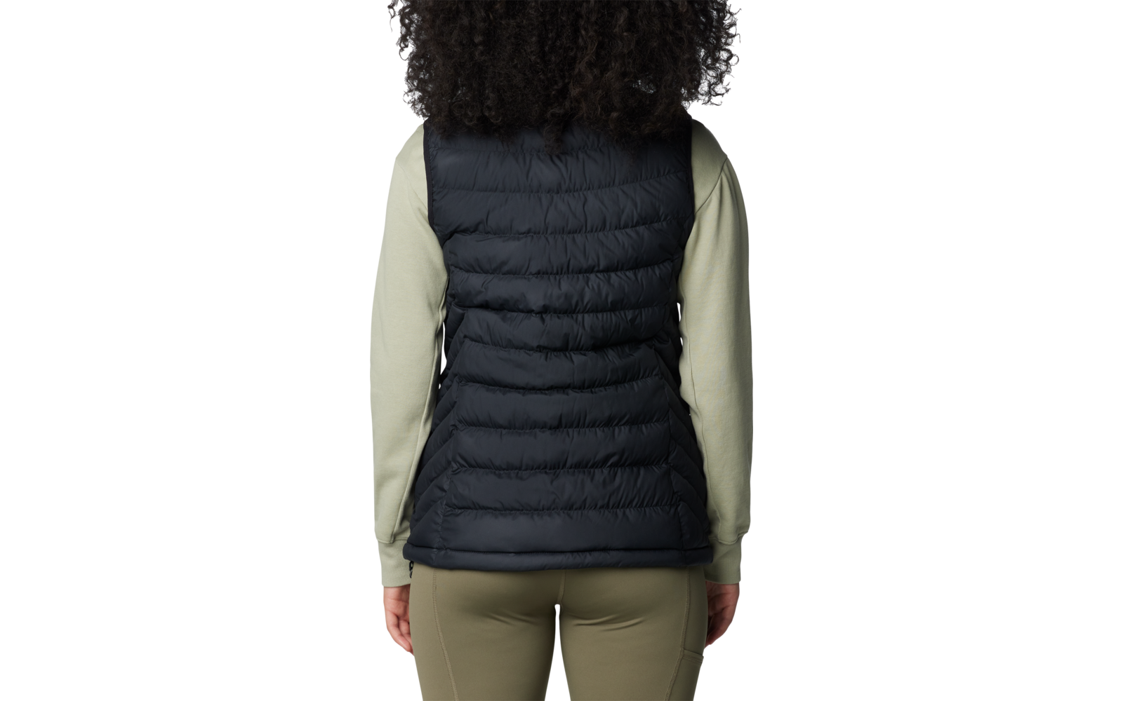 Person von hinten mit lockigem Haar und schwarzer Steppweste über hellgrünem Pullover
