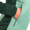 Hand steckt in Reißverschluss-Tasche einer hellgrünen Jacke