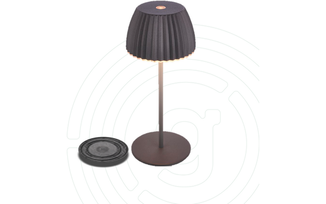 Tischlampe mit geripptem dunklem Schirm, dünnem Ständer und runder Basis; daneben eine flache, runde Scheibe