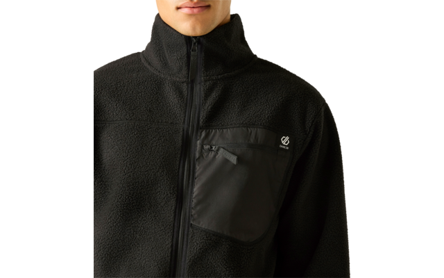 Oberkörper einer Person mit schwarzer Fleecejacke, mittiger Reißverschluss, Brusttasche mit kleinem weißem Logo; nur Mund und Kinn sichtbar