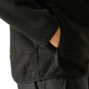 Schwarze Fleecejacke, rechte Hand in Reißverschlusstasche, sichtbarer Reißverschlussanhänger, flauschige Struktur