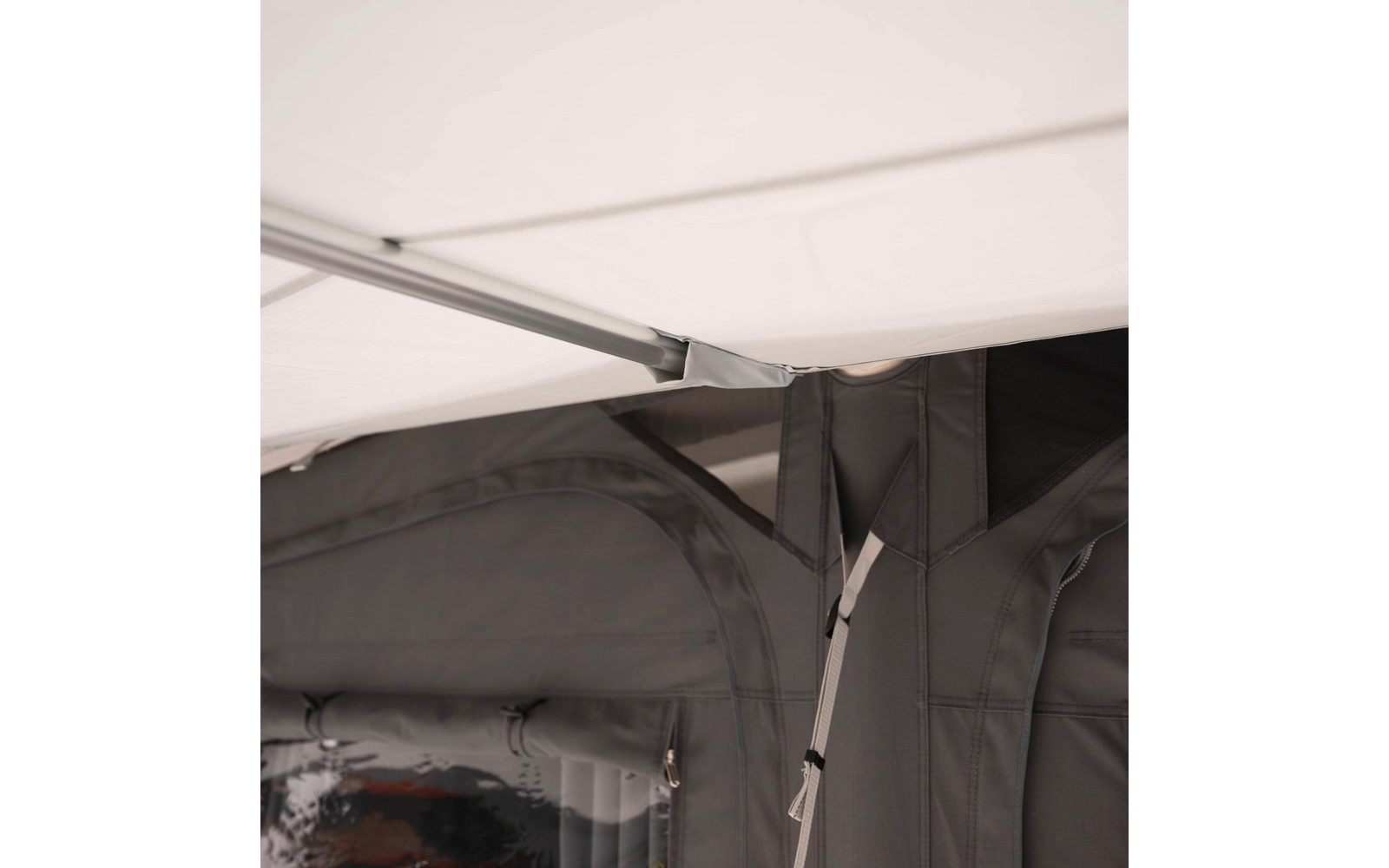 Nahaufnahme von grauen Stoffpanelen mit durchsichtigem Plastikfenster, Metallstange und Befestigungsriemen unter weißer Decke