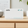 Weißes rechteckiges Gerät mit der Aufschrift "cello", 5G- und WiFi6-Symbole, Reihe von Status-LEDs und ein Power-Knopf, auf einer hellen Holzoberfläche; unscharfer Hintergrund mit Pflanze und Schale
