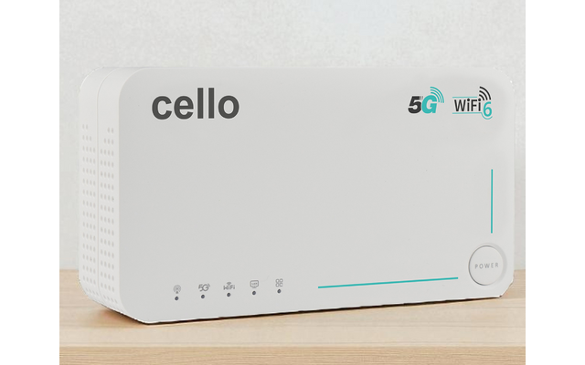 White rectangular device with 'cello' text, 5G and Wi‑Fi icons, vertical LED strip, round power button, small indicator lights and ventilation holes, on a wooden surface