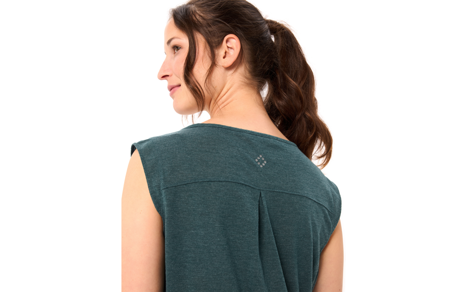 Frau von hinten im Profil, dunkler Pferdeschwanz, grünes ärmelloses Oberteil mit Rückenfalte und kleinem quadratischem Emblem