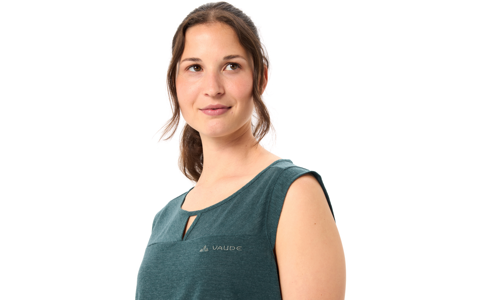 Porträt einer jungen Frau mit braunem Pferdeschwanz, Blick nach rechts, trägt ein ärmelloses dunkelgrünes Oberteil mit kleinem VAUDE-Logo auf der Brust