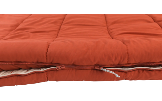 Nahaufnahme eines orangenen, gefalteten Schlafsacks mit sichtbarem Reißverschluss