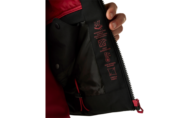 Hand hält Innenklappe einer Jacke offen, schwarze Innenfütterung mit roten Symbolen und offenem Reißverschluss